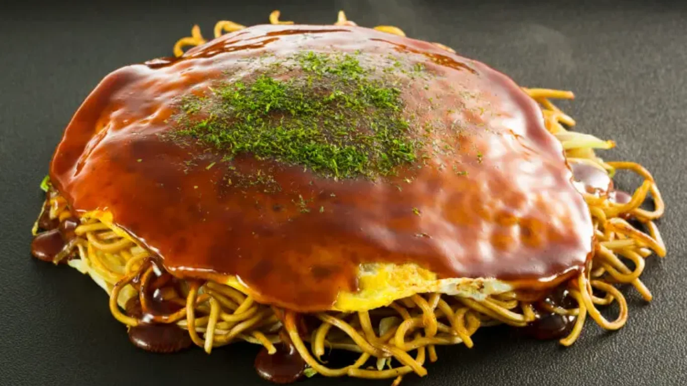 鉄板の上で焼かれる広島風お好み焼き