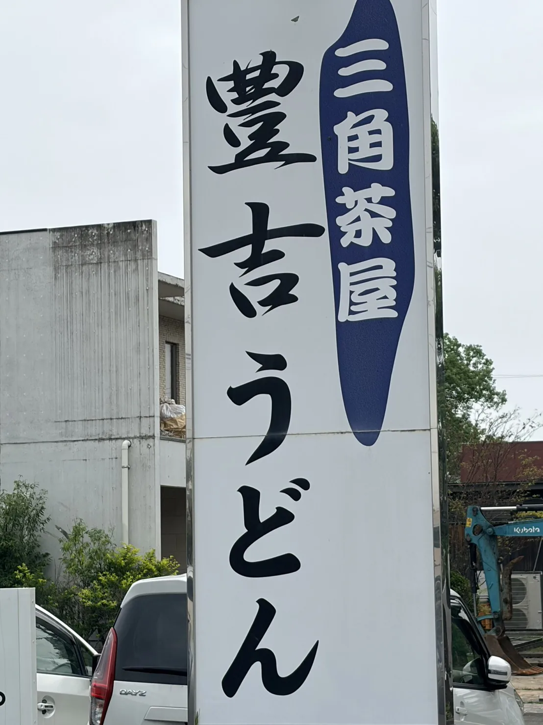 「三角茶屋 豊吉うどん」と書かれた白地に黒文字の柱看板